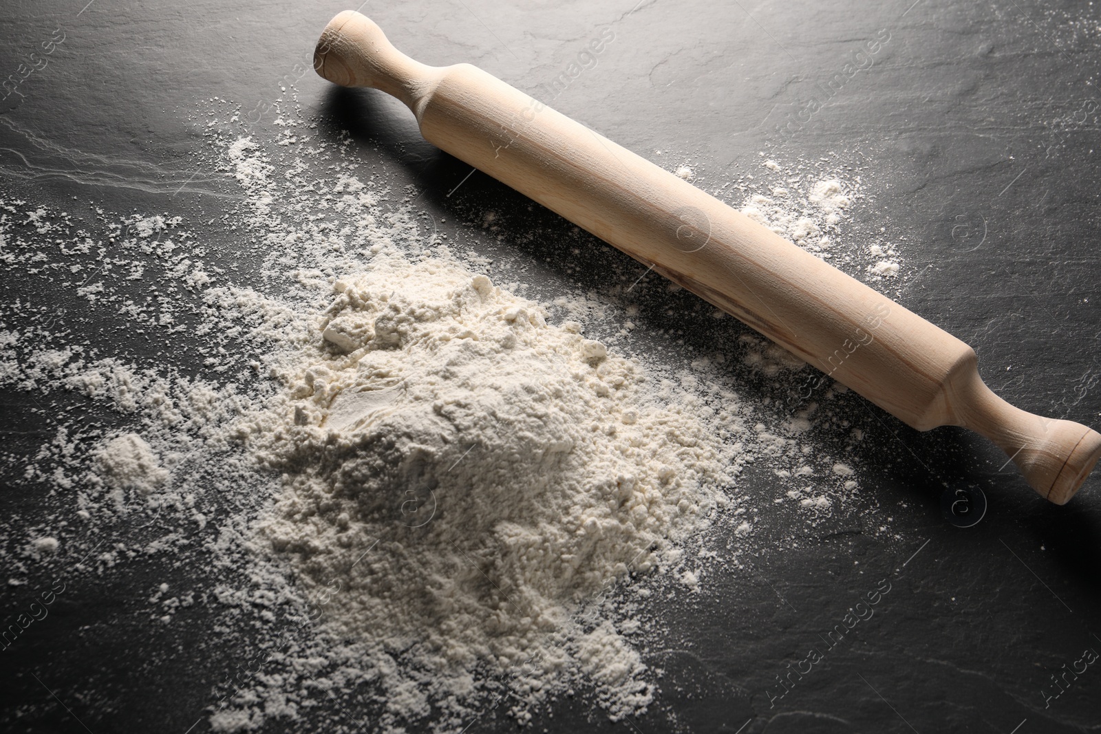 Photo of Pile of flour and rolling pin on grey textured table, above view