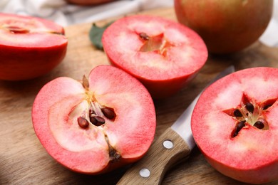 Tasty apples with red pulp and knife on wooden board, closeup
