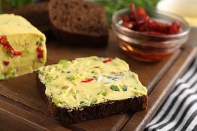 Photo of Tasty butter with green onion, chili pepper and rye bread on table, closeup