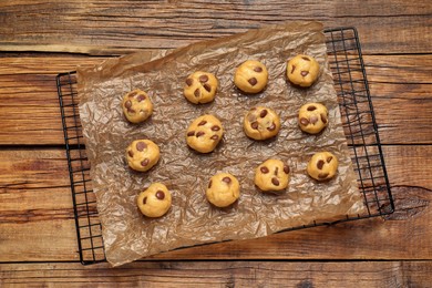 Unbaked chocolate chip cookies on wooden table, top view