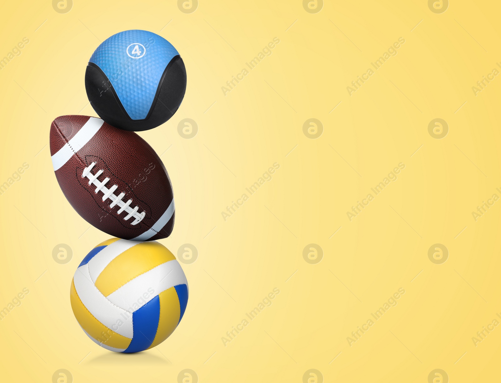 Image of Stack of different sport and medicine balls on light gold background, space for text