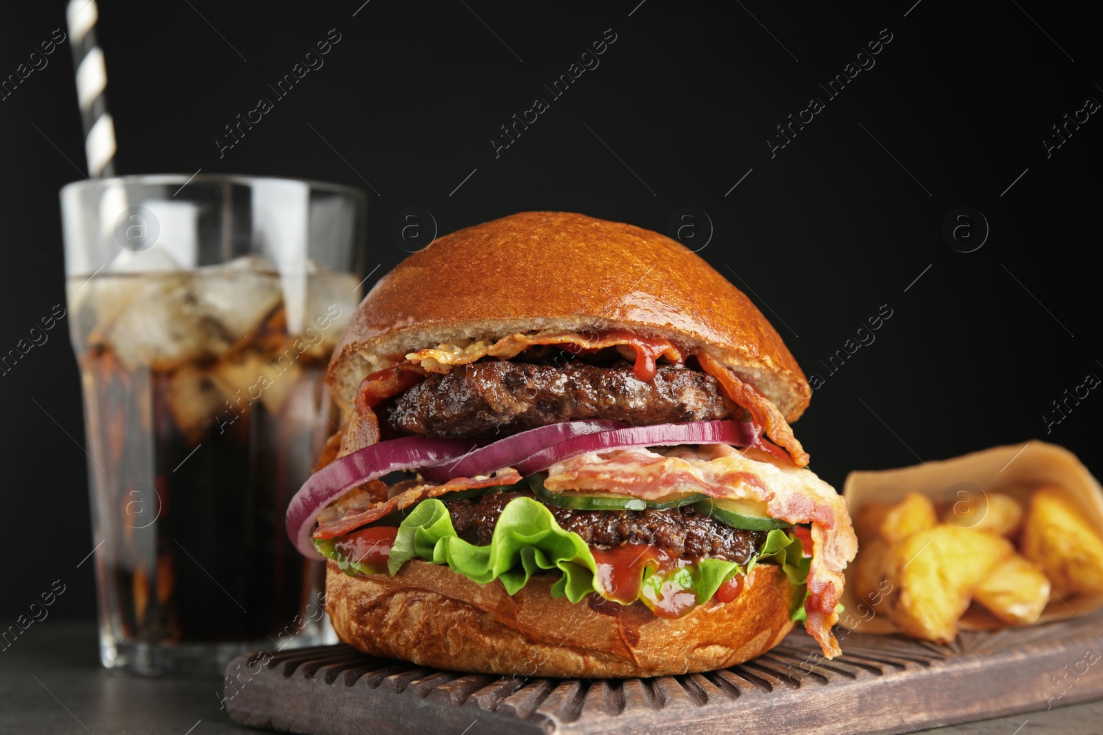Photo of Tasty burger with bacon and fried potatoes served on table