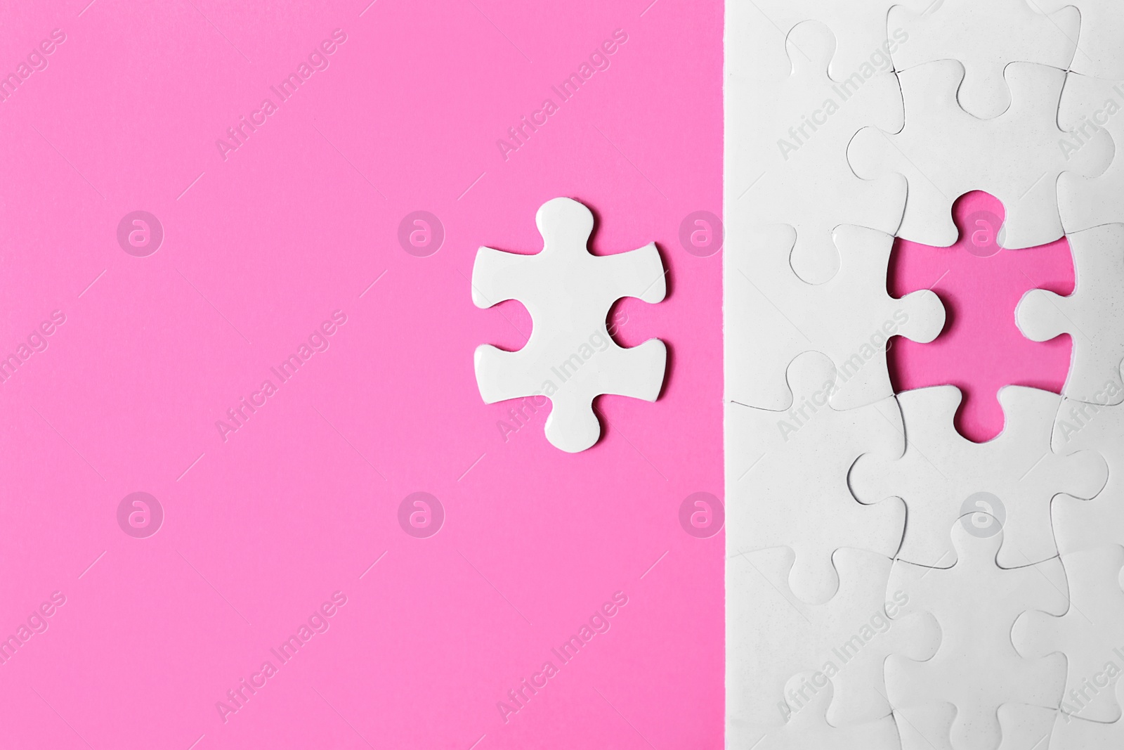 Photo of Blank white puzzle with separated piece on pink background, flat lay. Space for text