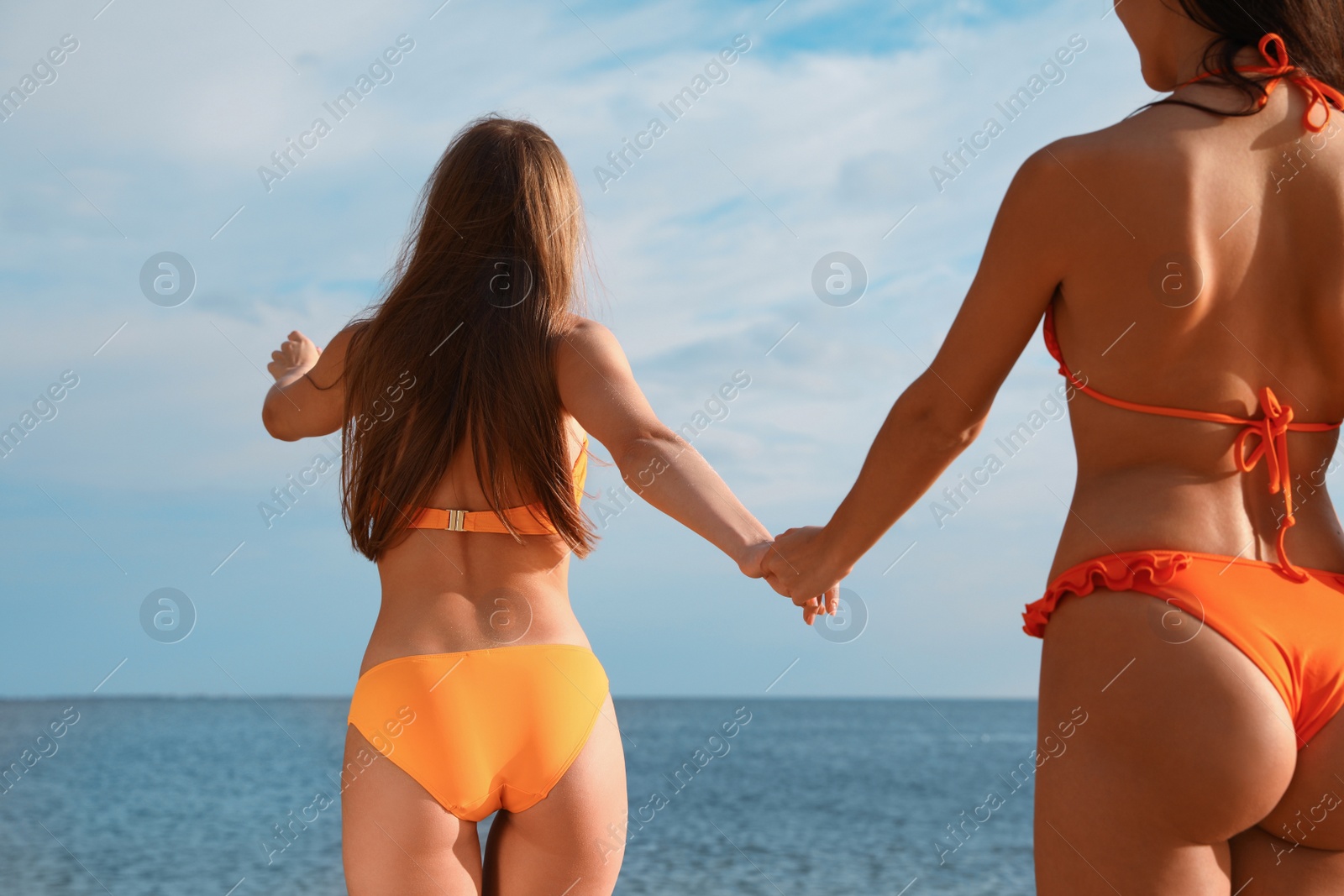 Photo of Young couple in bikini spending time together on beach