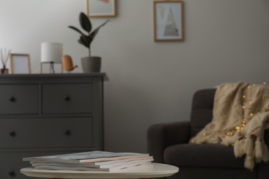 Stack of magazines on white table in stylish living room