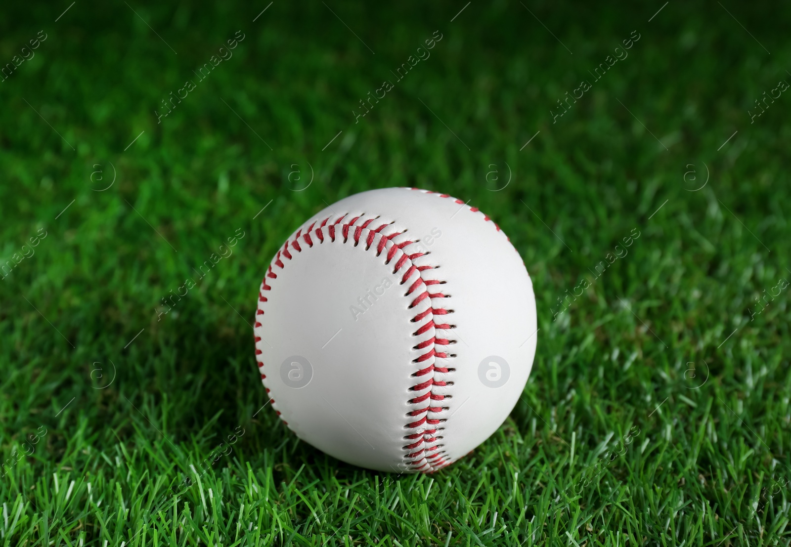 Photo of Baseball ball on green grass, closeup. Sports game