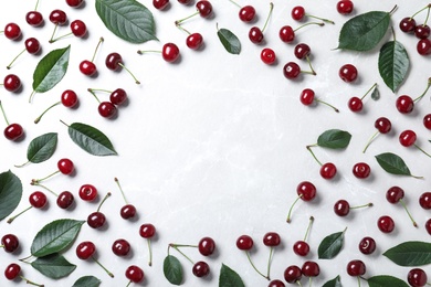 Sweet juicy cherries on white table, flat lay. Space for text
