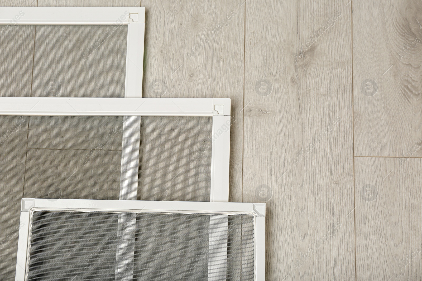 Photo of Set of window screens on wooden floor, flat lay. Space for text