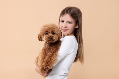 Photo of Little child with cute puppy on beige background. Lovely pet