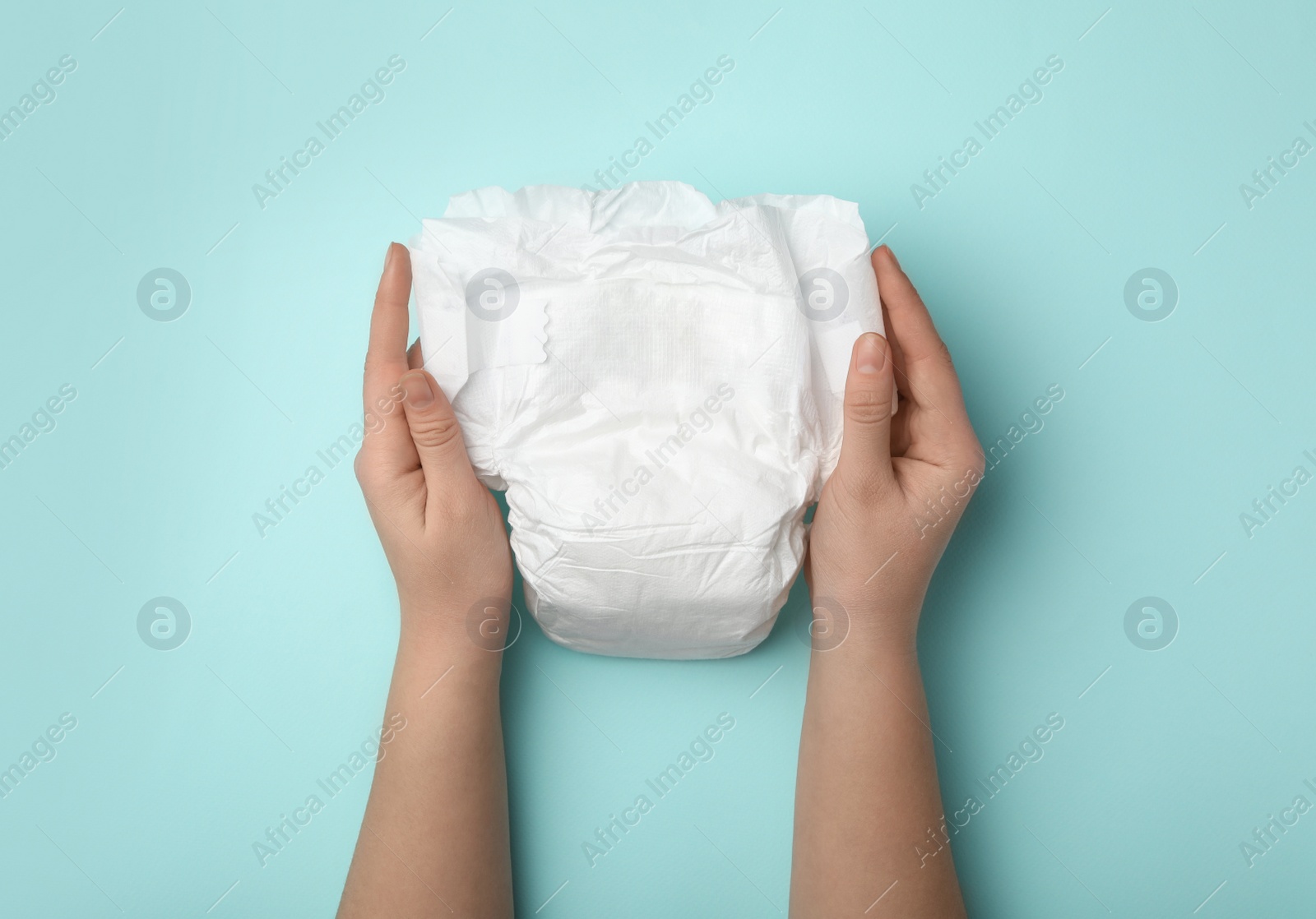 Photo of Woman with diaper on turquoise background, closeup