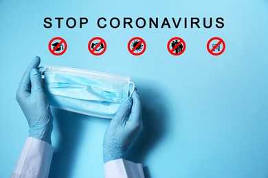 Protective measures during pandemic. Doctor holding medical mask near text Stop Coronavirus and illustrations on light blue background