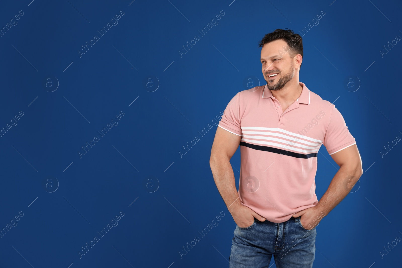 Photo of Portrait of handsome man on dark blue background. Space for text
