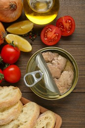Photo of Flat lay composition with tin can of tasty cod liver and different products on wooden table