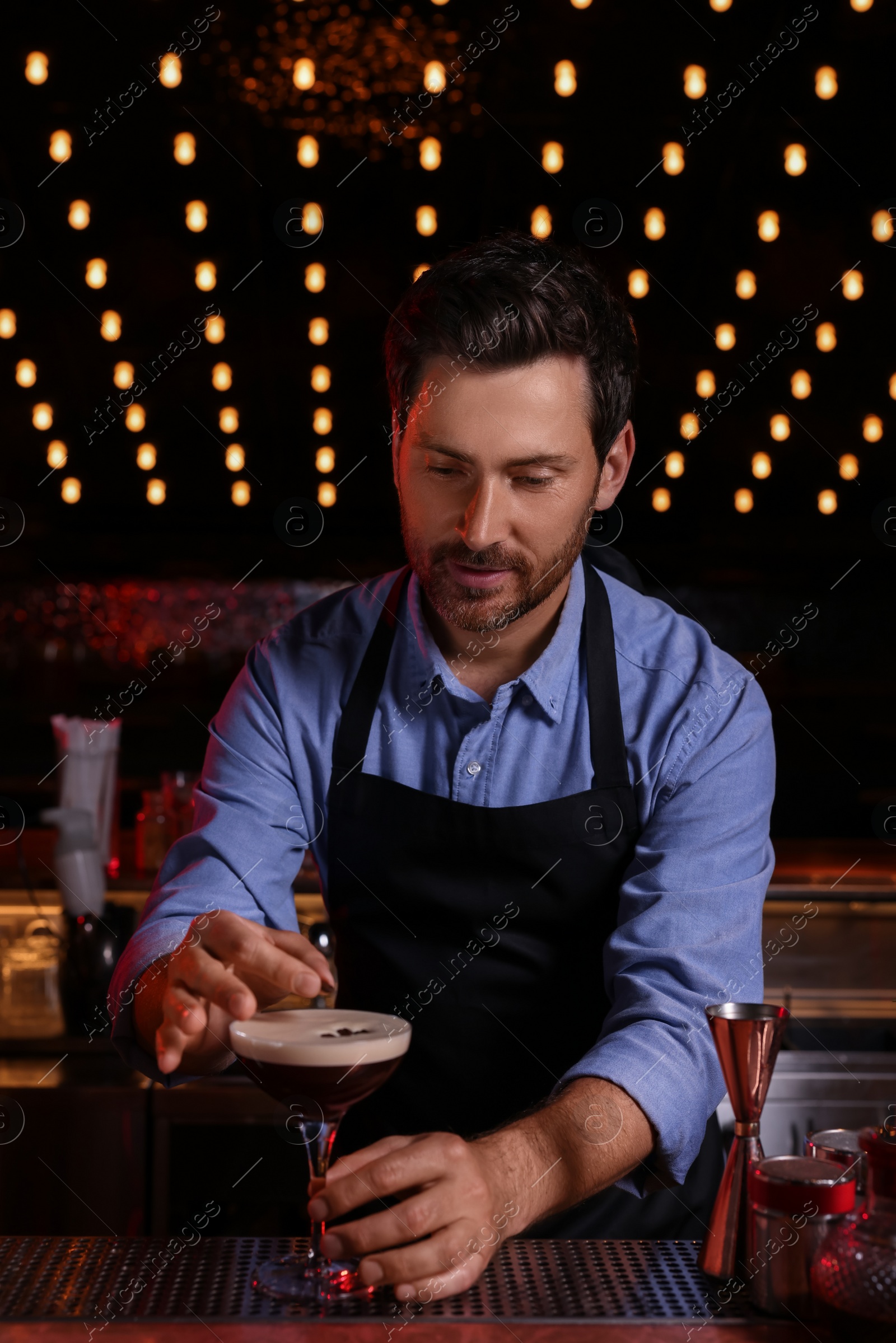 Photo of Bartender preparing Espresso Martini in bar. Alcohol cocktail