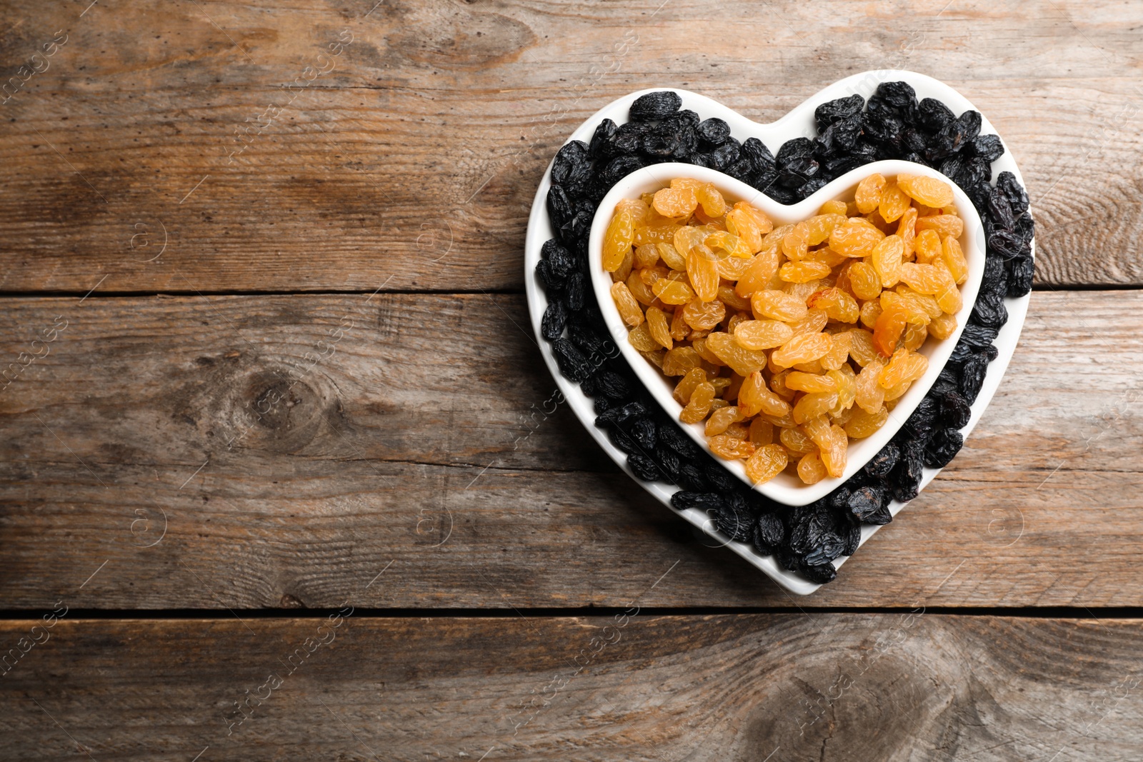 Photo of Flat lay composition with raisins and space for text on wooden background. Dried fruit as healthy snack