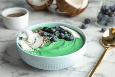 Photo of Bowl of spirulina smoothie served on marble table