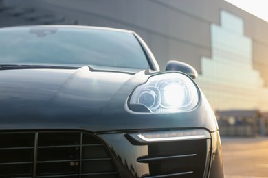 Photo of Modern black car parked outdoors, closeup view