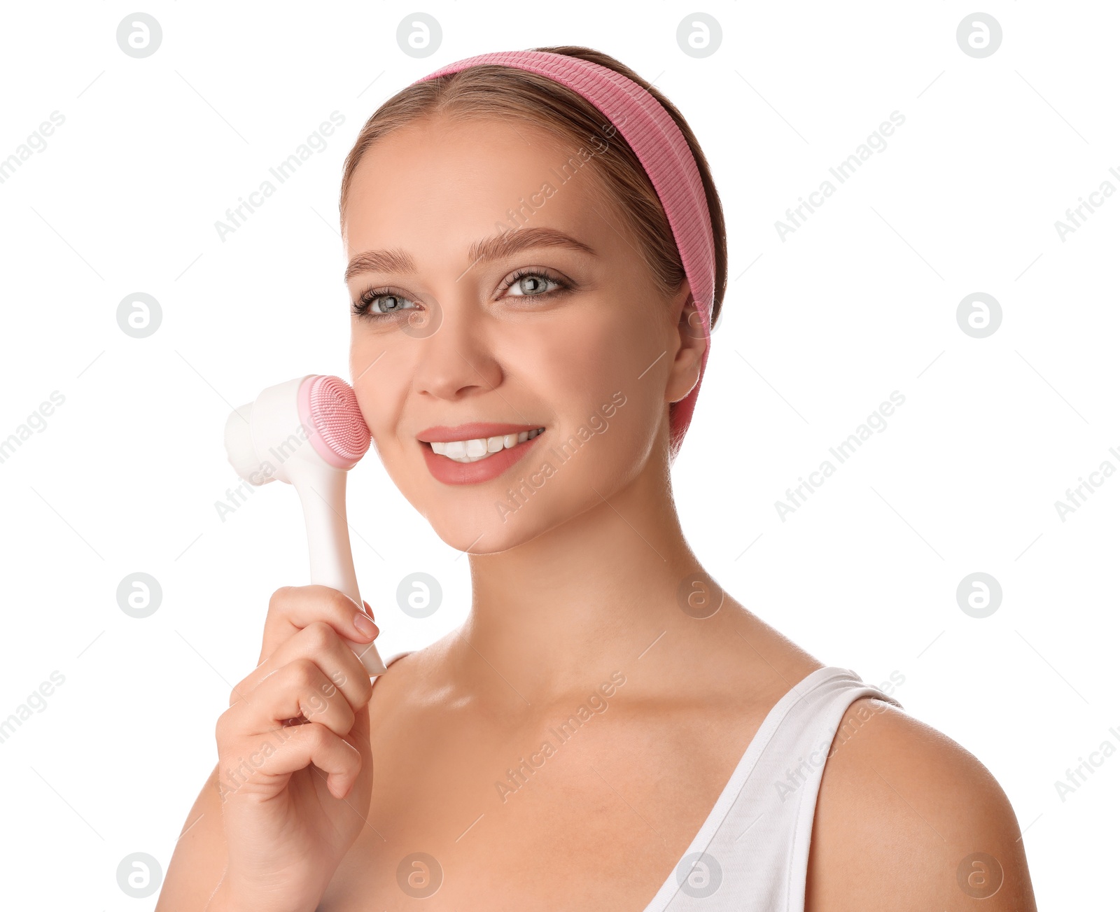 Photo of Young woman washing face with cleansing brush on white background. Cosmetic product