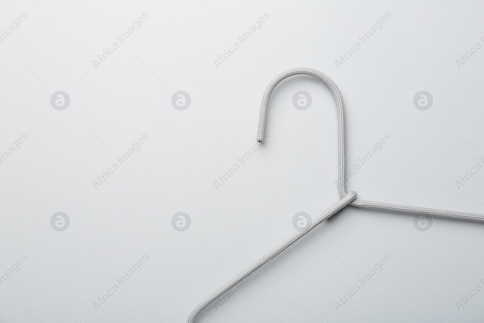 Photo of Hanger on light gray background, top view. Space for text