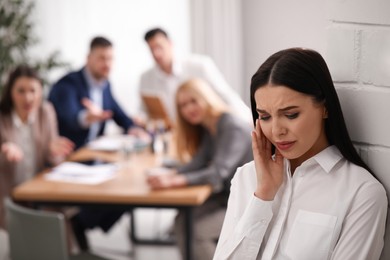 Photo of Coworkers bullying their colleague in office, space for text