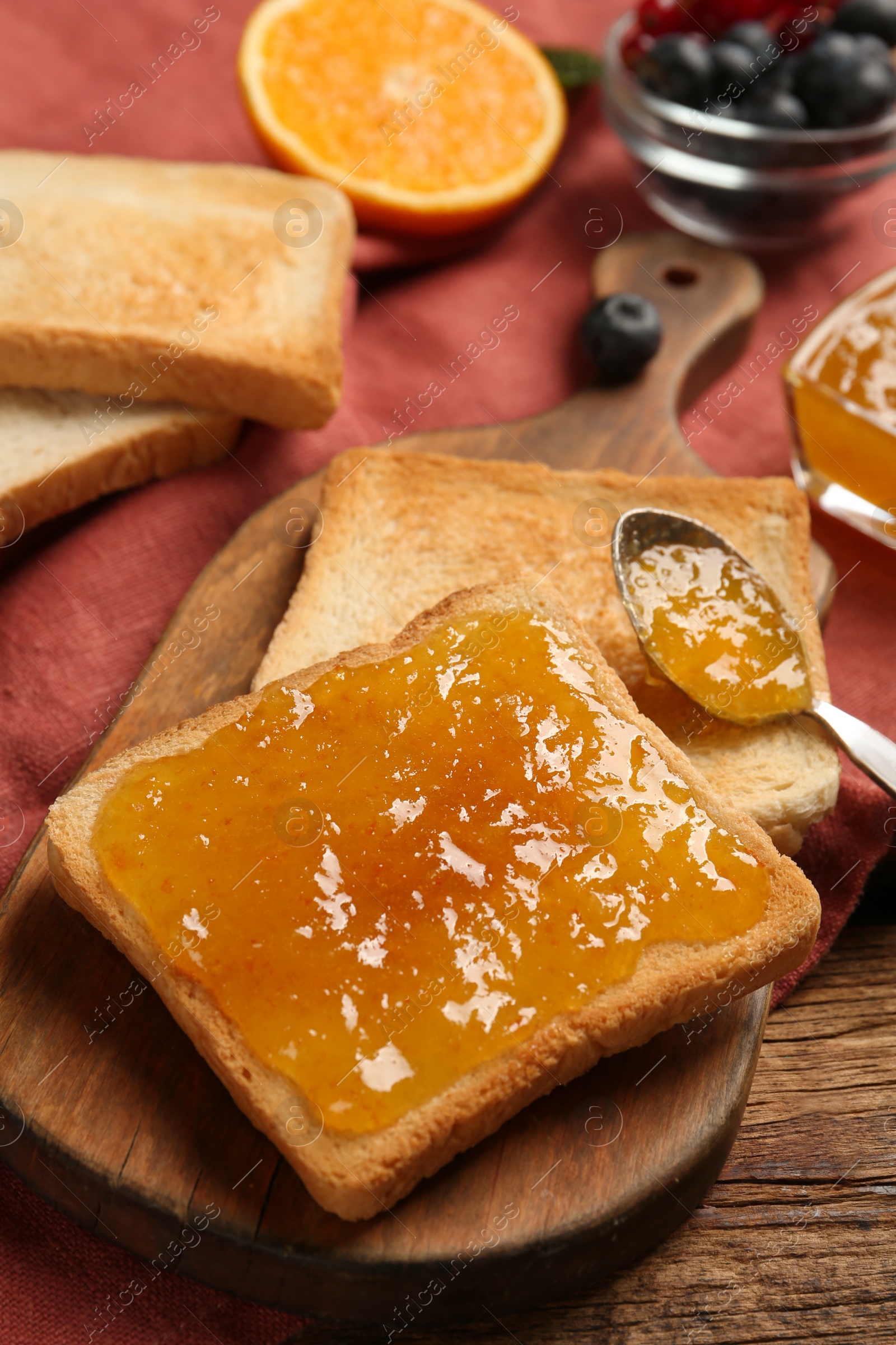 Photo of Delicious toasts with jam served on wooden table