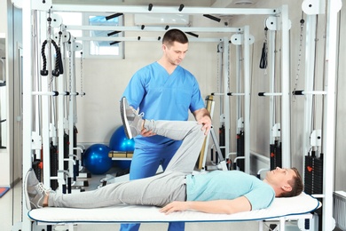 Photo of Physiotherapist working with patient in rehabilitation center