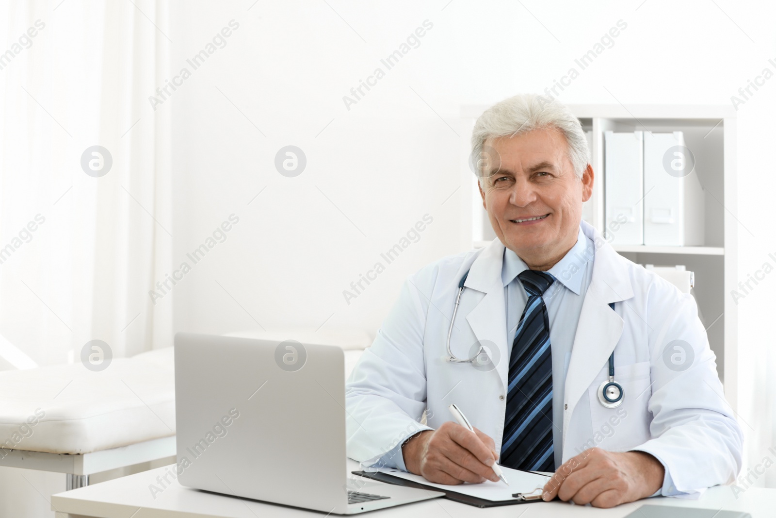 Photo of Portrait of senior doctor in white coat at workplace