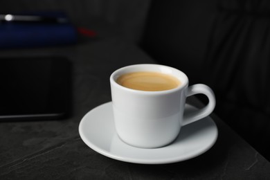 Photo of Coffee Break at workplace. Cup of hot espresso on grey table