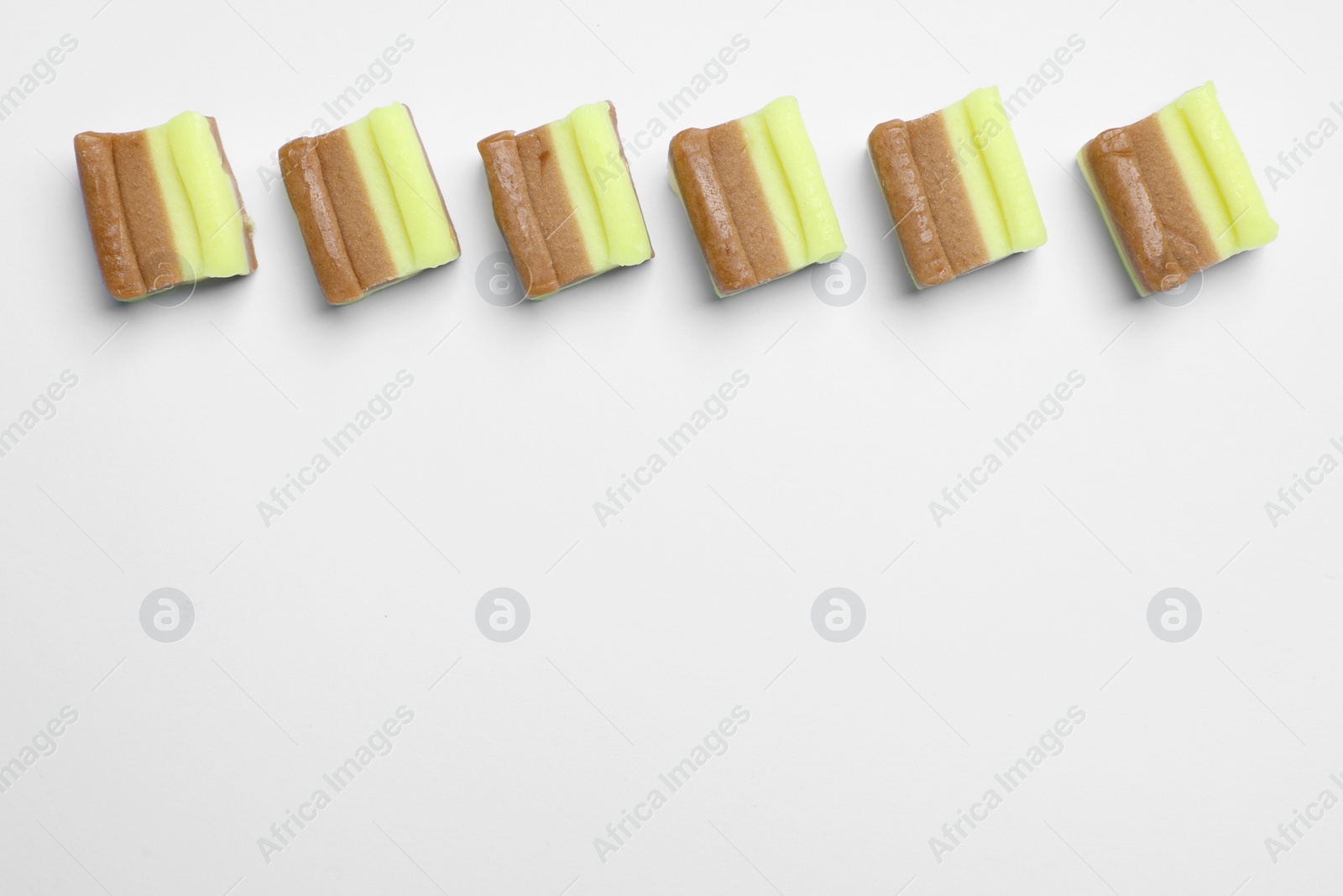 Photo of Tasty colorful bubble gums on white background, flat lay. Space for text