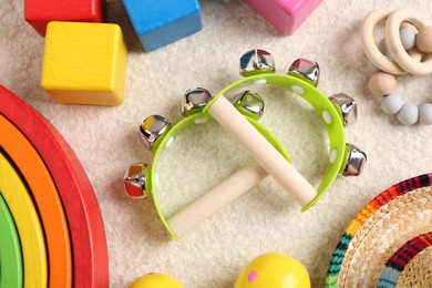 Baby song concept. Wooden tambourines and toys on beige carpet, flat lay