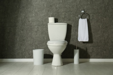 Photo of Simple bathroom interior with new toilet bowl near grey wall