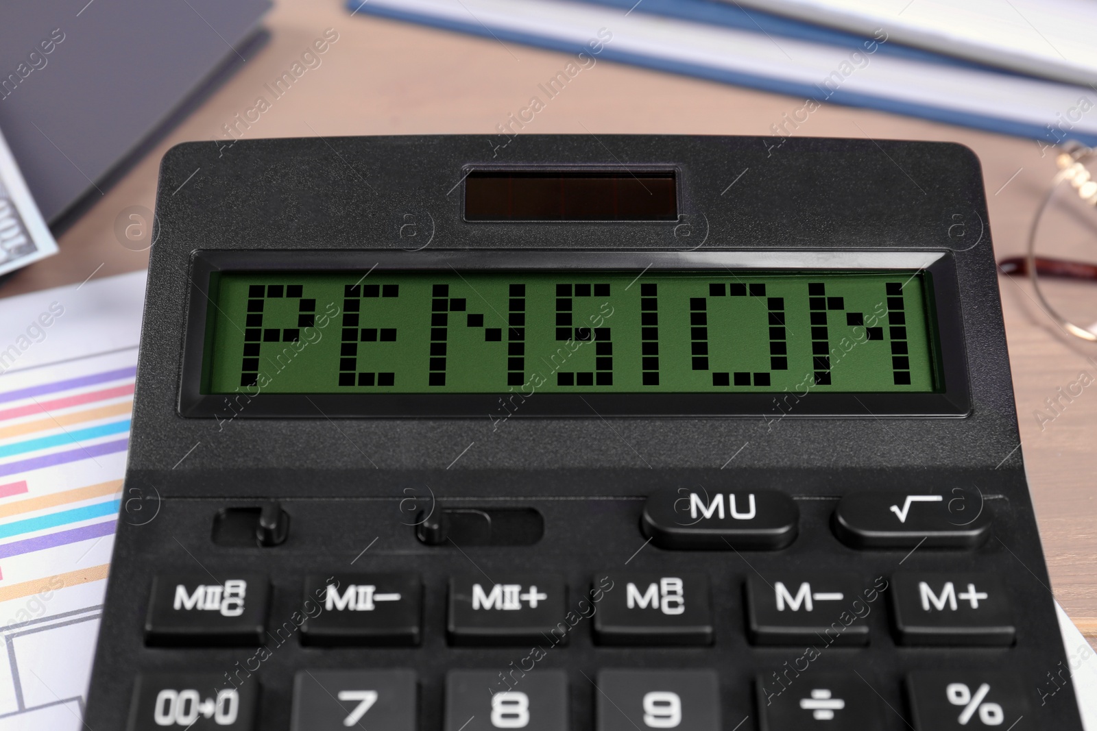 Image of Calculator with word Pension on table, closeup