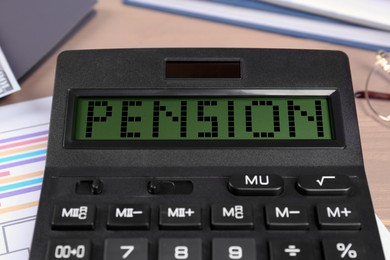 Calculator with word Pension on table, closeup