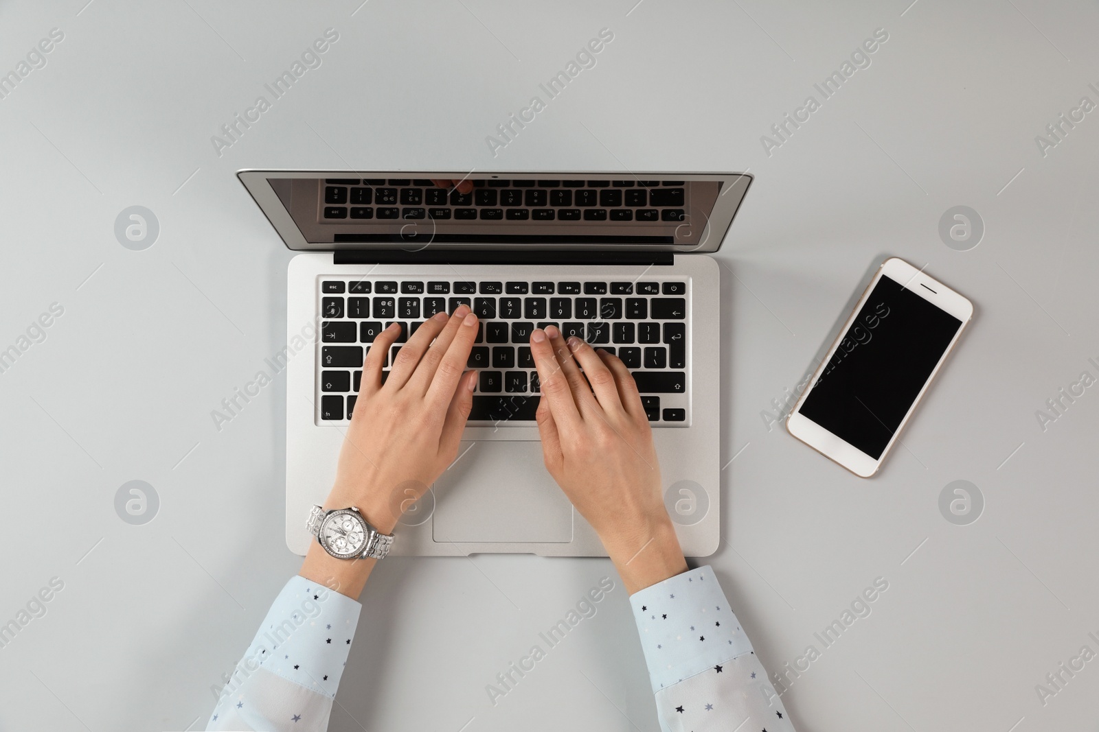 Photo of Woman using modern laptop at table, top view