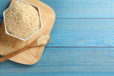 White sesame seeds on light blue wooden table, flat lay. Space for text