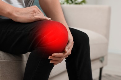 Image of Woman suffering from rheumatism in knee at home, closeup
