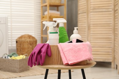 Photo of Different cleaning products in wooden box on table indoors