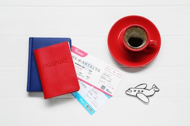 Photo of Flat lay composition with passport, cup of coffee and tickets on white wooden table. Business trip