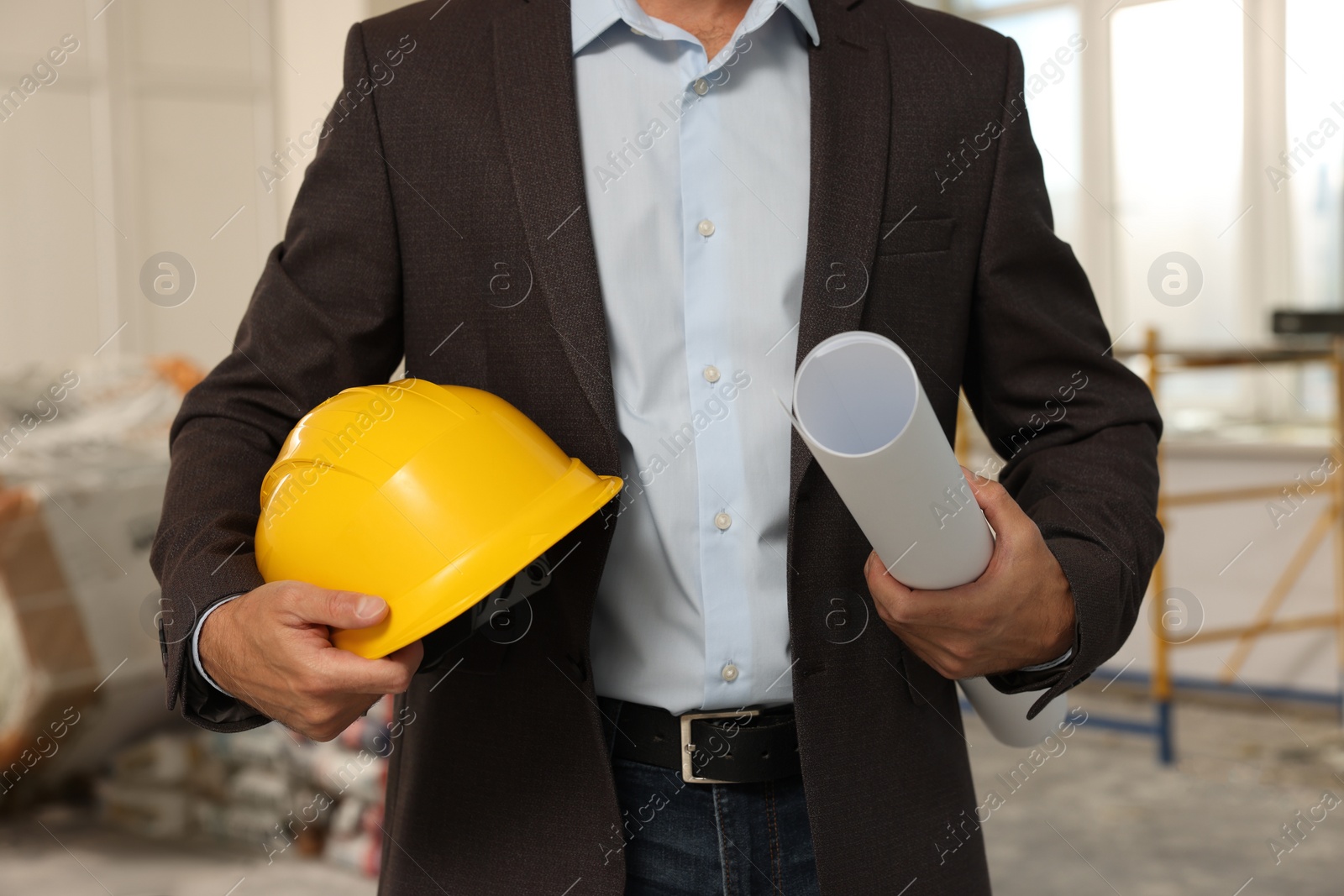 Photo of Professional engineer with hard hat and draft indoors, closeup