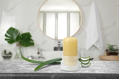 Image of Natural crystal alum deodorant and aloe on grey table in bathroom