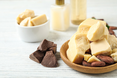 Composition with organic cocoa butter on white wooden table, closeup