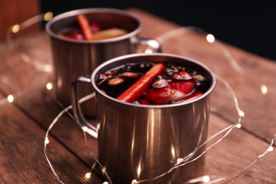 Photo of Tasty aromatic mulled wine on wooden table