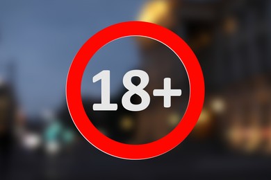 Image of Age limit sign 18+ years and blurred view of night city