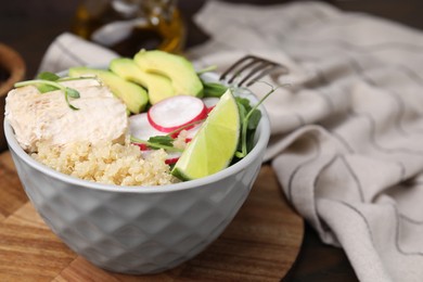 Delicious quinoa salad with chicken, avocado and radish served on table, closeup