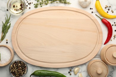 Wooden cutting board and spices on white marble table, flat lay. Space for text