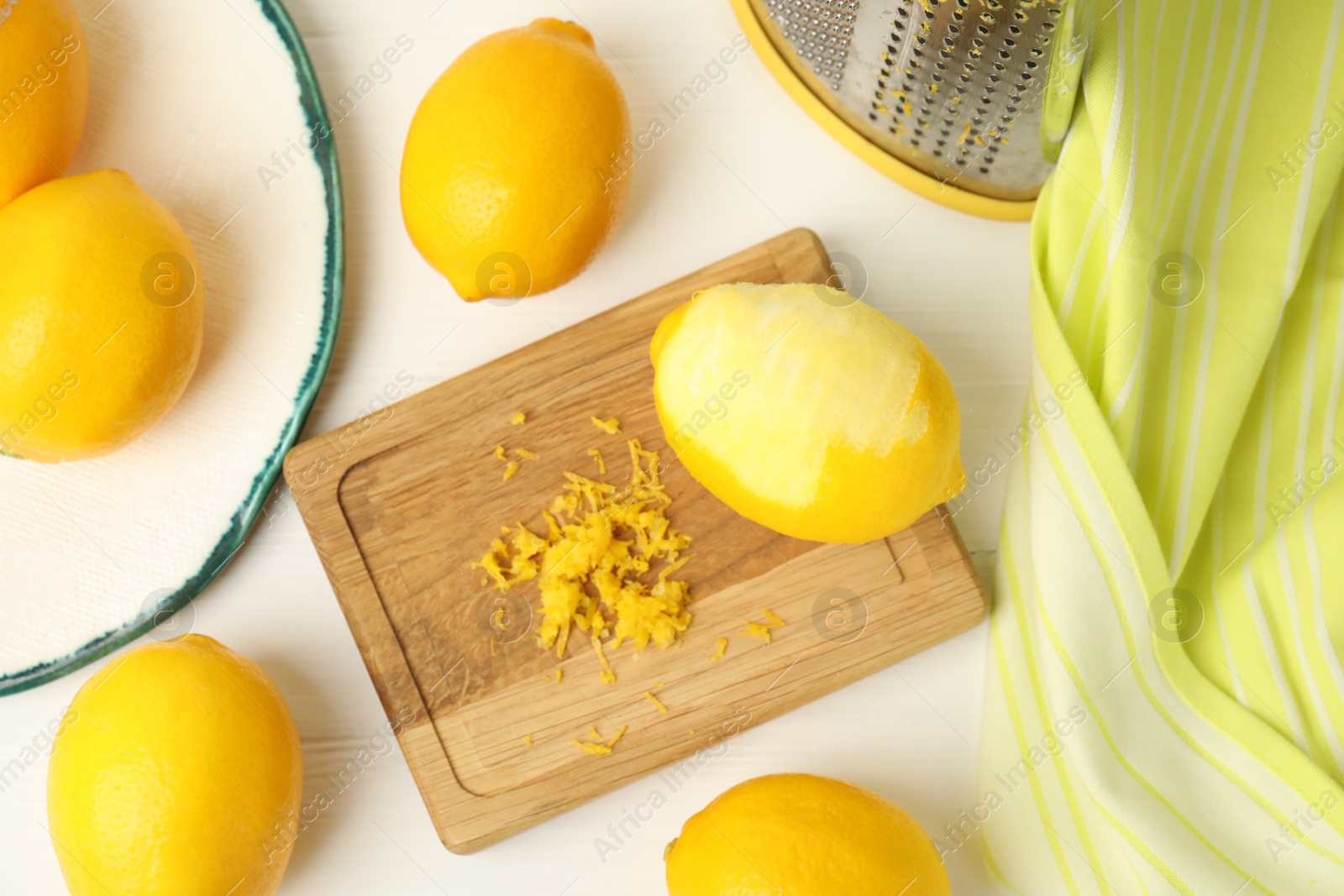 Photo of Lemon zest and fresh fruits on white wooden table, flat lay