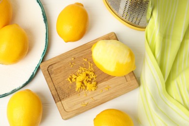 Lemon zest and fresh fruits on white wooden table, flat lay