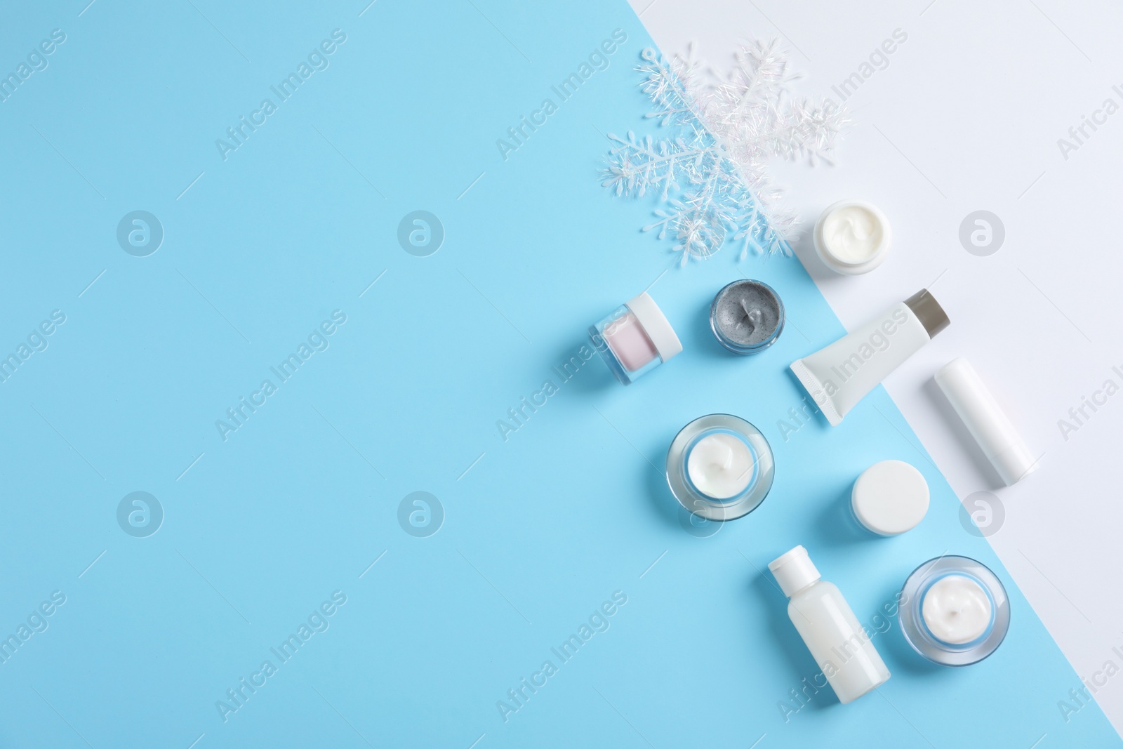 Photo of Set of cosmetic products on color background, flat lay with space for text. Winter care