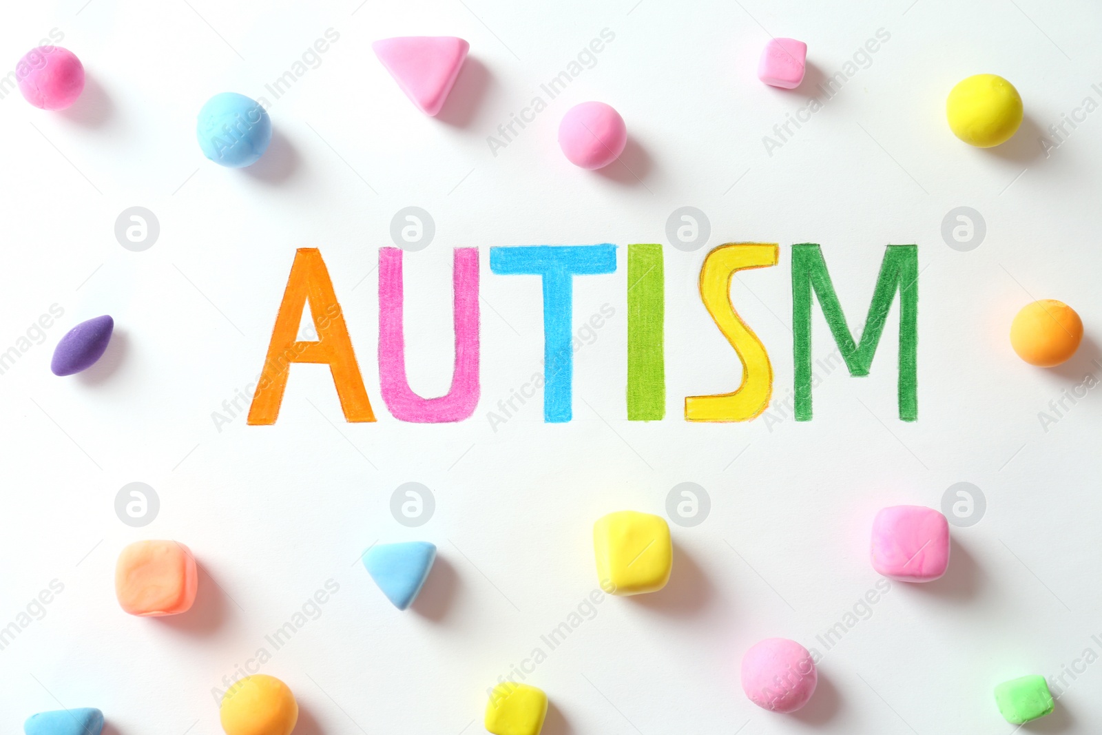 Photo of Word Autism and colorful plasticine figures on white background, flat lay