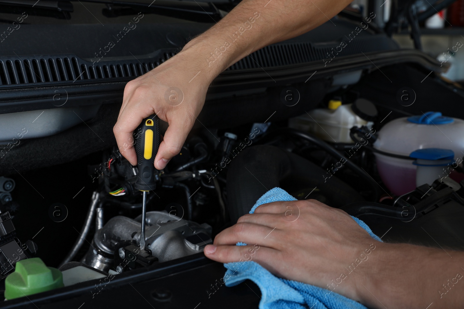 Photo of Professional auto mechanic fixing modern car in service center, closeup